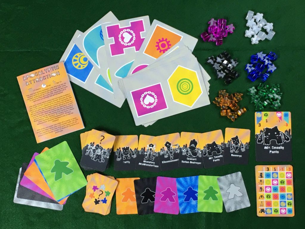 apocalyptic attraction components spread: rule book, city cards, monster cards, guessing cards, and plastic meeples in six colors